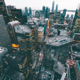 A dense city skyline beneath a bright afternoon sky