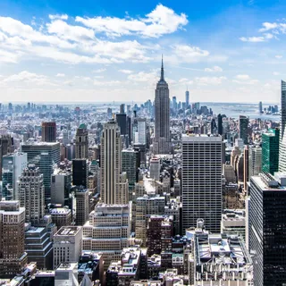 A high-rise skyline with a broadcast tower in the distance